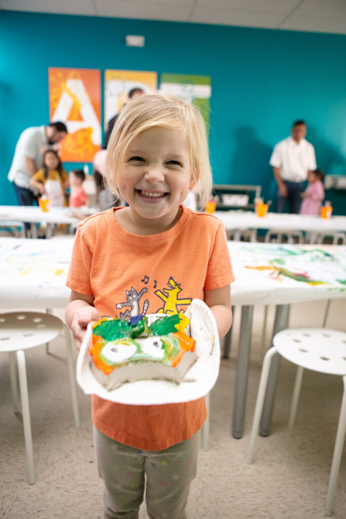 kid showing off her art project